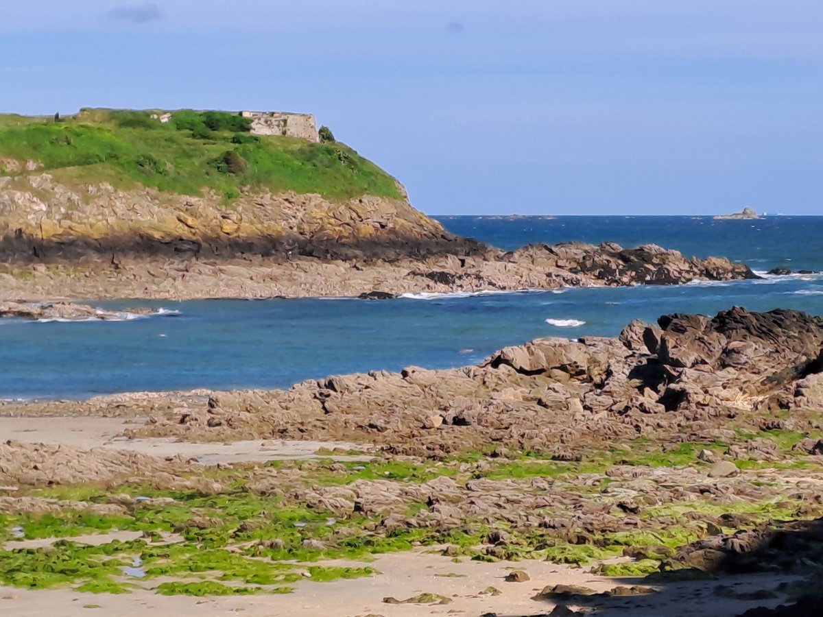 Paysage côtier rocheux avec une ancienne forteresse en Bretagne.