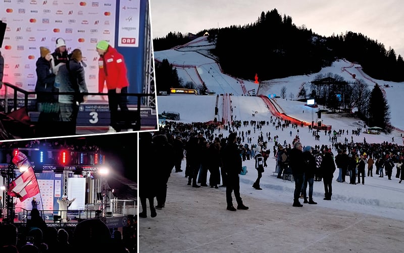 Podium des vainqueurs, scène illuminée de nuit et foule au pied de la Streif au crépuscule