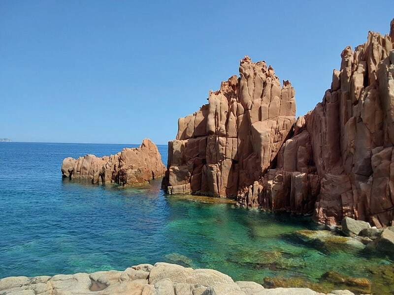 Rochers de porphyre rouge d’Arbatax plongeant dans une eau turquoise et transparente