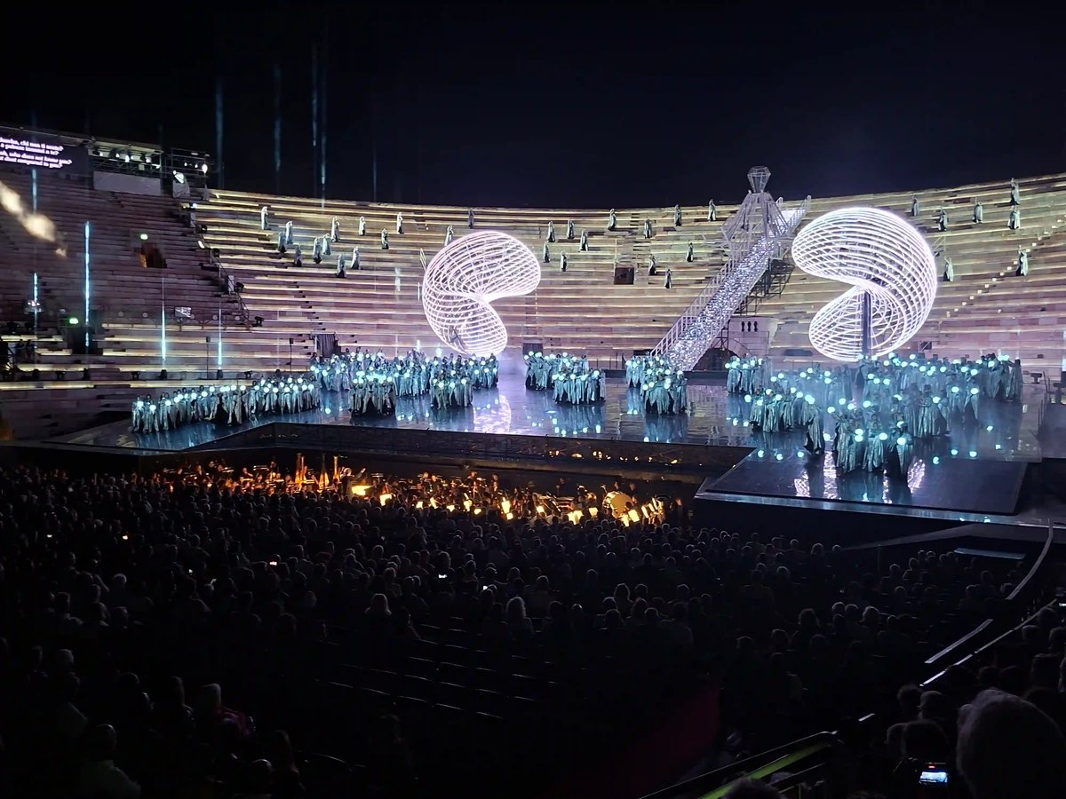 Nächtliche Opernaufführung in der Arena di Verona mit grossem Ensemble auf der Bühne.