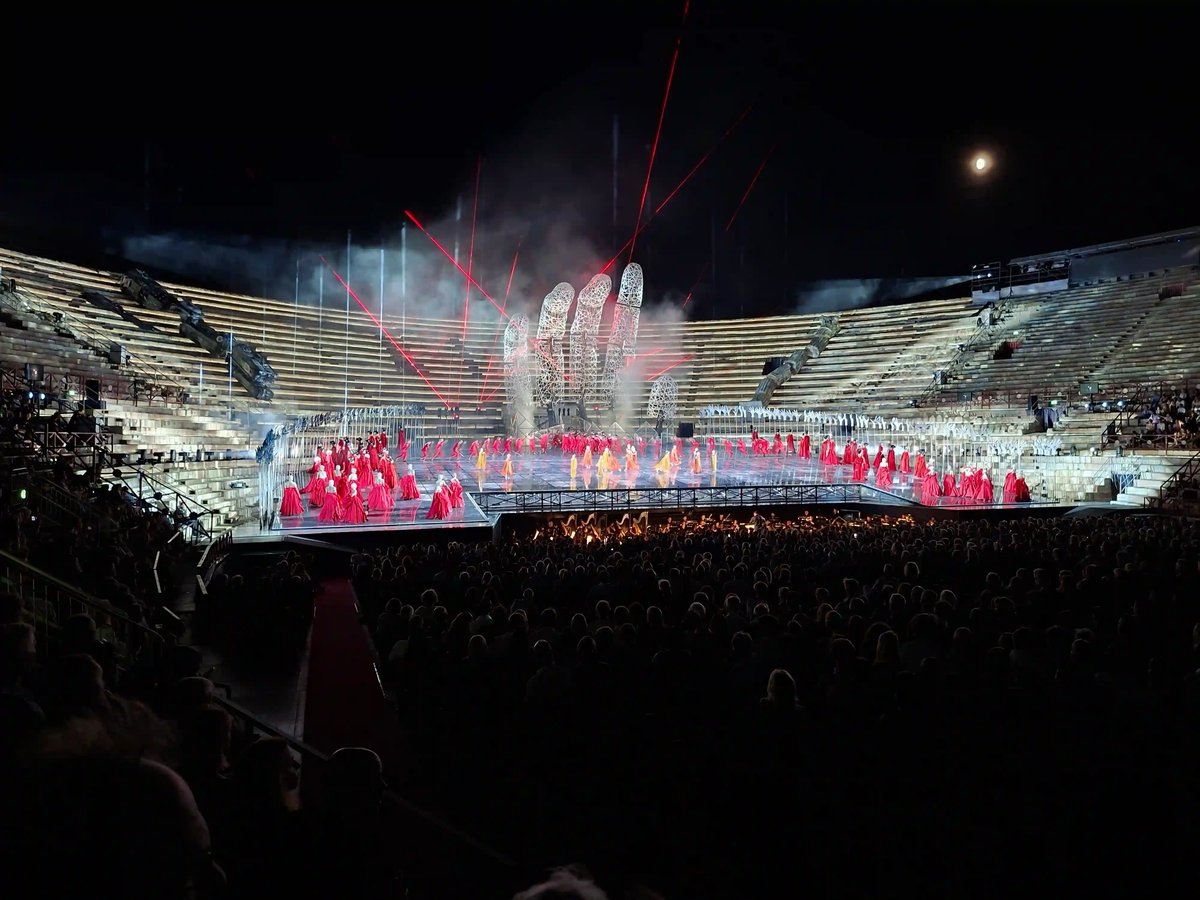 Farbenprächtige Opernaufführung in der Arena di Verona mit rotem Bühnenbild und Lichteffekten.