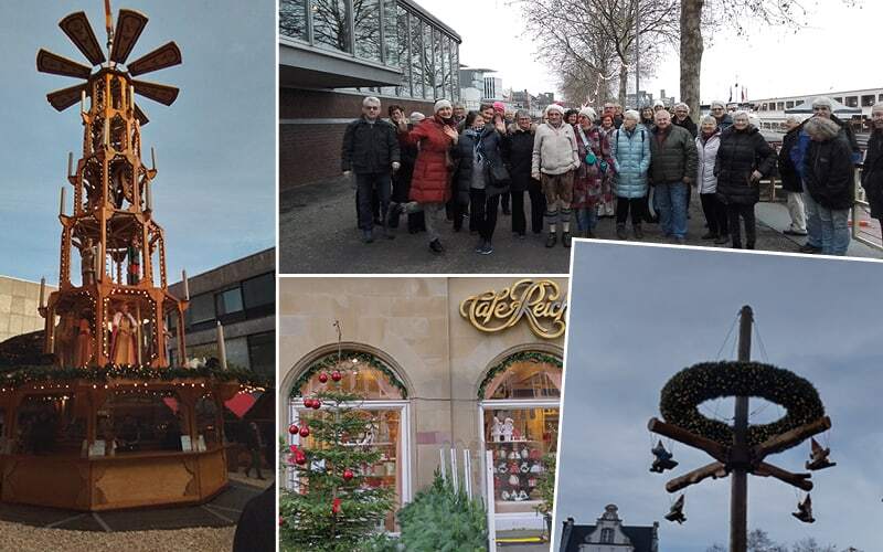 Pyramide de Noël en bois, groupe de voyageurs souriants, façade du Café Reichard décorée pour Noël