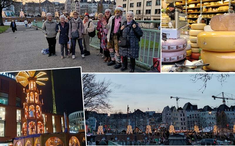 Voyageurs d’humeur festive, étal de meules de fromage et marché de Noël illuminé au crépuscule