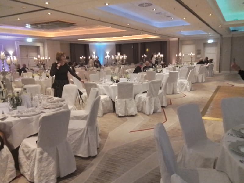 Salle de gala dressée pour le Nouvel An, avec candélabres et chaises habillées de blanc