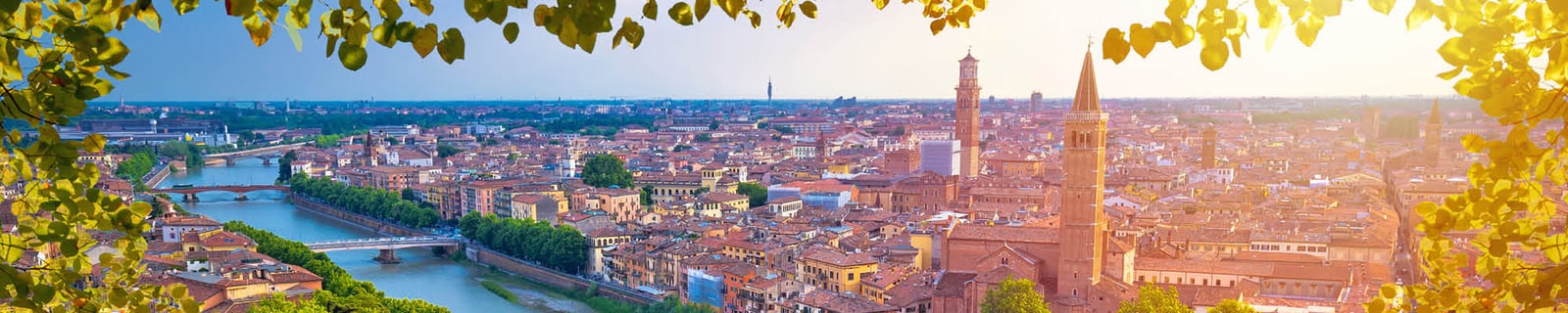 Panorama des toits de Vérone et de l’Adige au coucher du soleil, encadré de feuillage