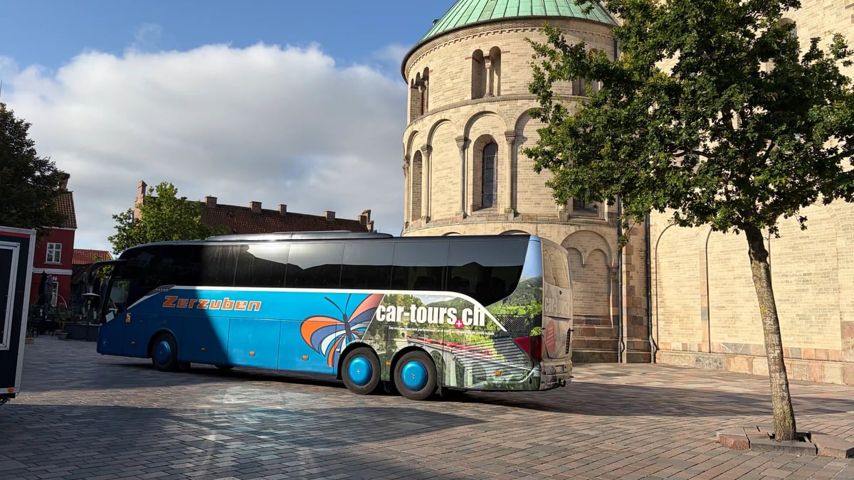 car-tours.ch Reisebus vor einer historischen Kirche in Dänemark.