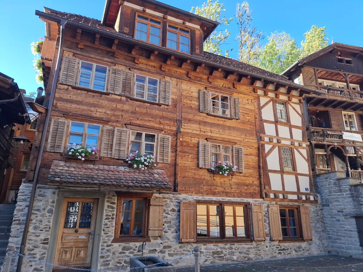 Façade d'une maison traditionnelle en bois avec plusieurs fenêtres et balcons