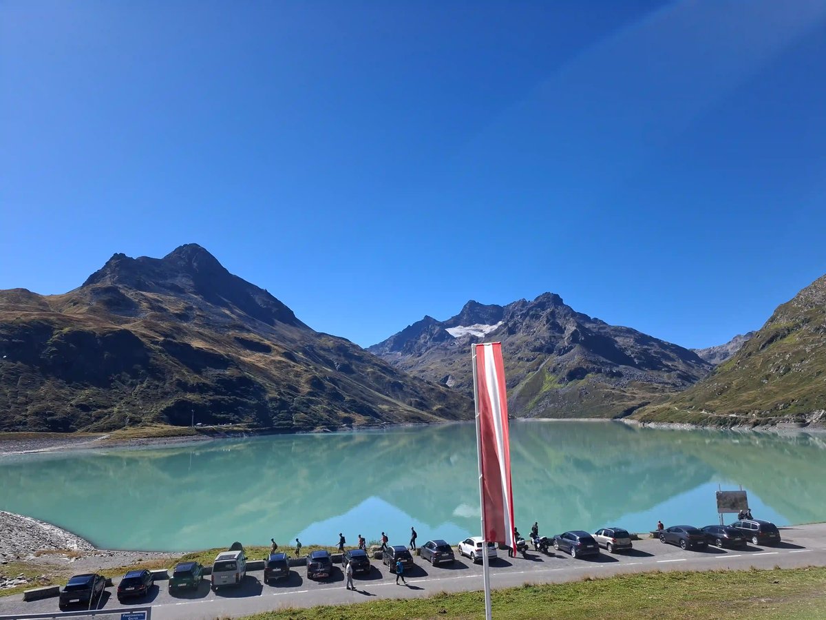 Lac turquoise de Silvretta entouré de sommets alpins sous un ciel bleu