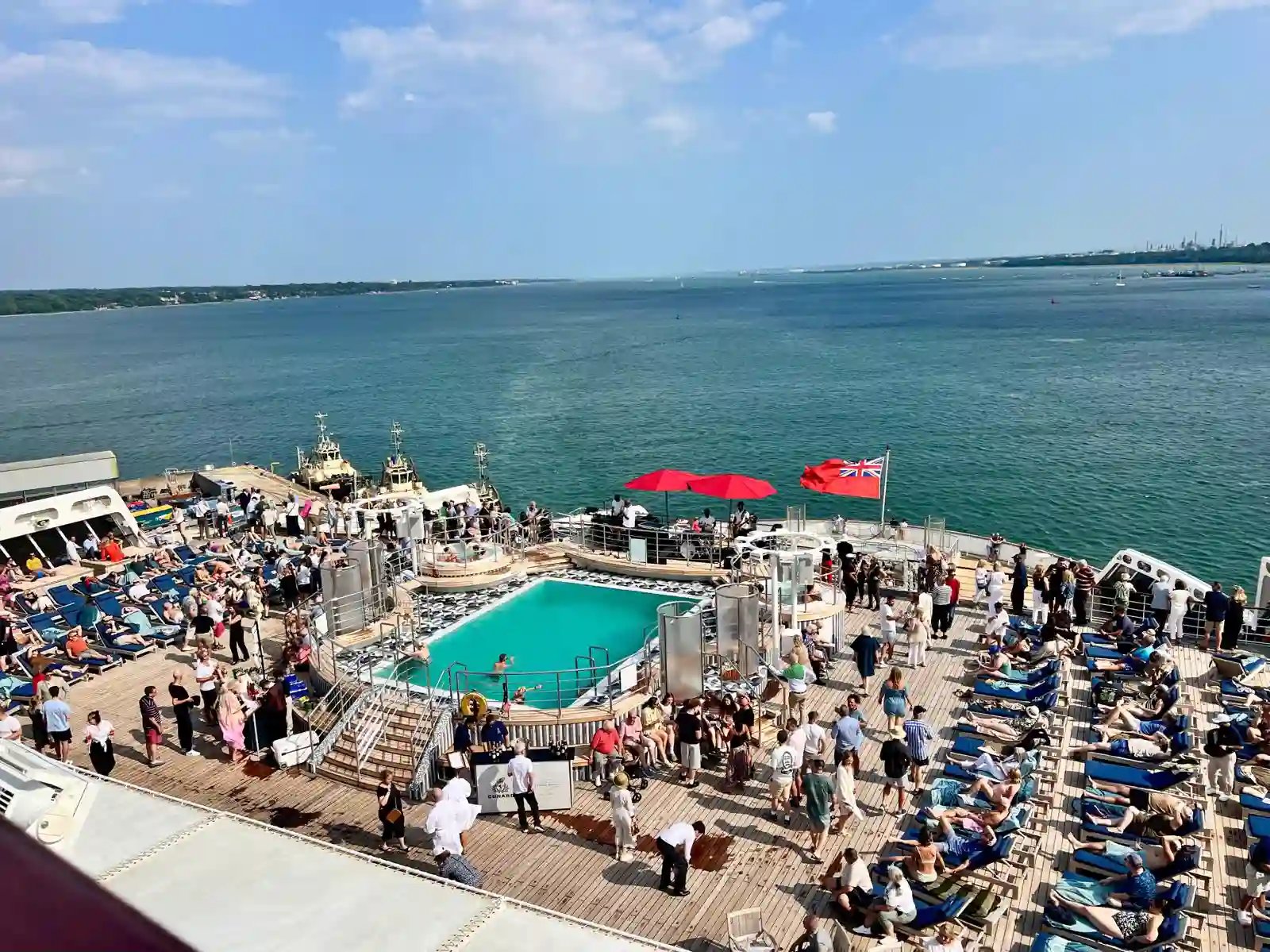 Sonnendeck der Queen Mary 2 mit Pool, Liegestühlen und Blick auf das Meer