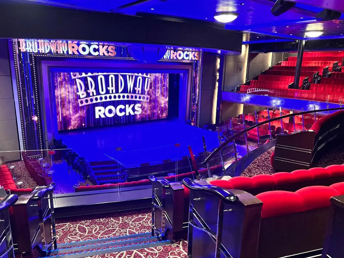 Bordtheater der Queen Mary 2 mit Bühne, rotem Gestühl und beleuchtetem Broadway-Rocks-Schriftzug