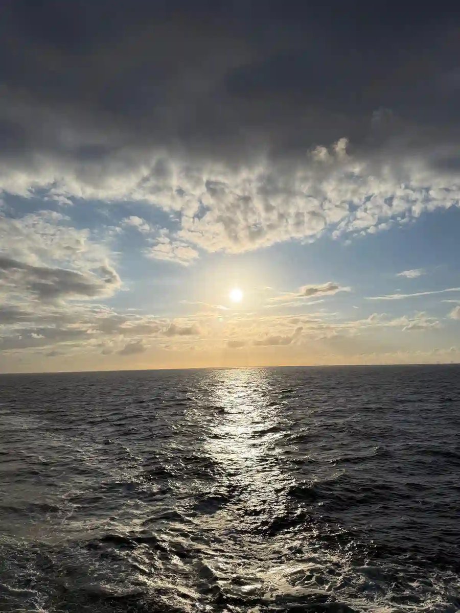 Sonnenuntergang über dem Meer mit leuchtender Spiegelung auf dem Wasser.