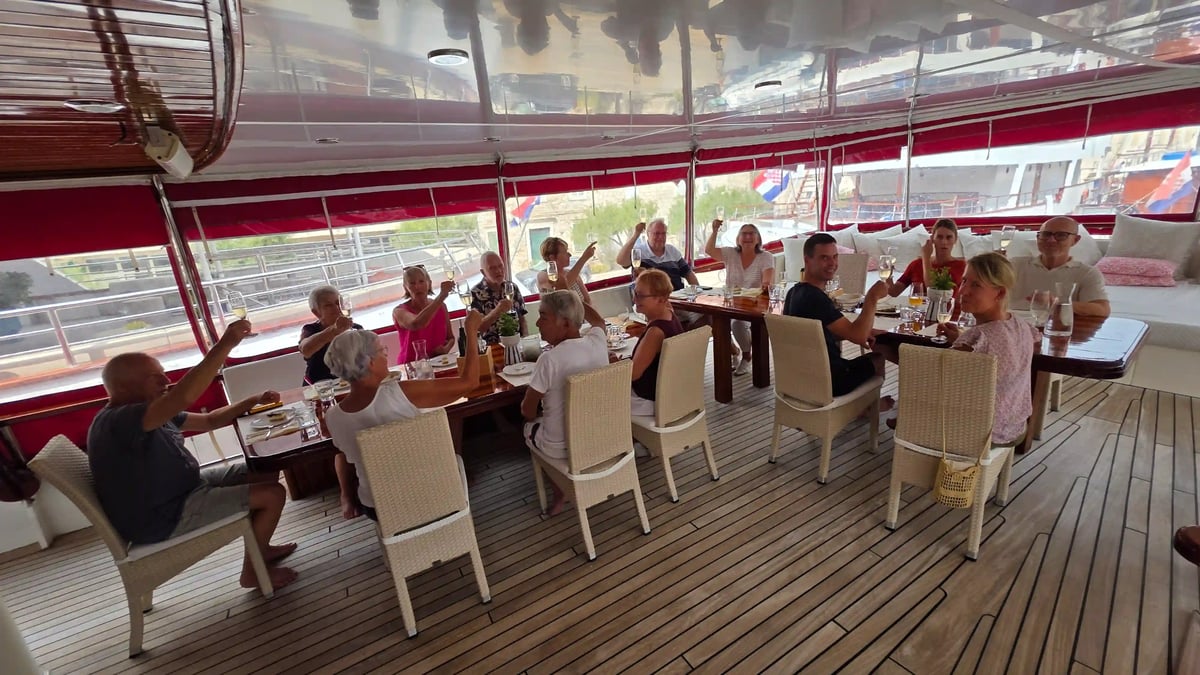 Voyageurs réunis autour d’une table pour partager un repas sur le pont du yacht