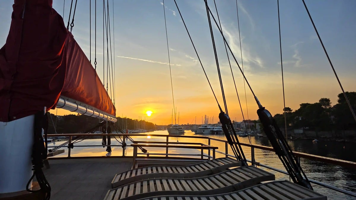 Chaises longues sur le pont du yacht avec vue sur la mer dans la lumière du soir