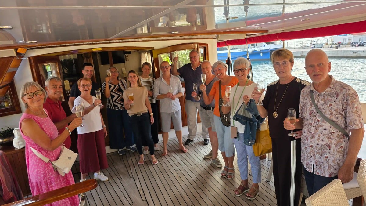 Les voyageurs trinquent ensemble lors de l’apéritif de bienvenue sur le pont du yacht Barbara