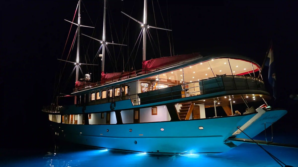 Le yacht Barbara illuminé de nuit, amarré dans un port de la côte dalmate