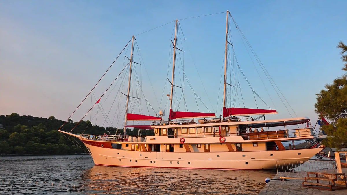 Le yacht Barbara à trois mâts, amarré près de la côte croate dans la lumière du soleil couchant