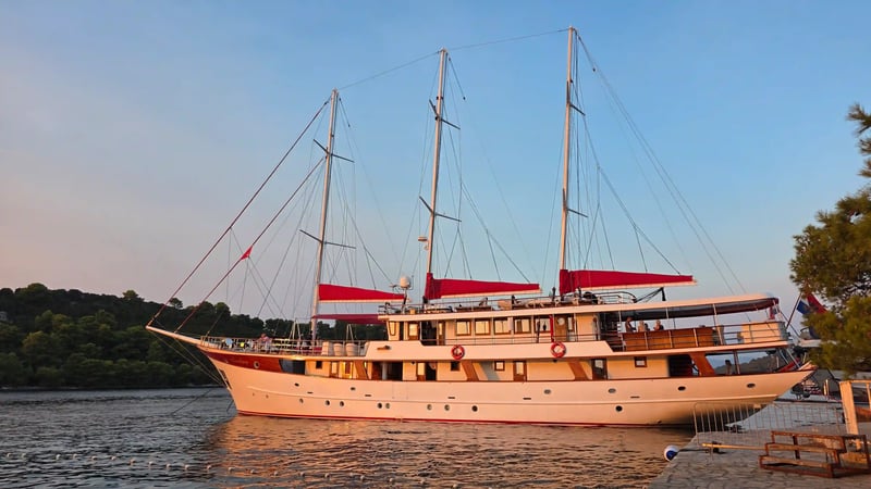 Le yacht Barbara à trois mâts, amarré près de la côte croate dans la lumière du soleil couchant