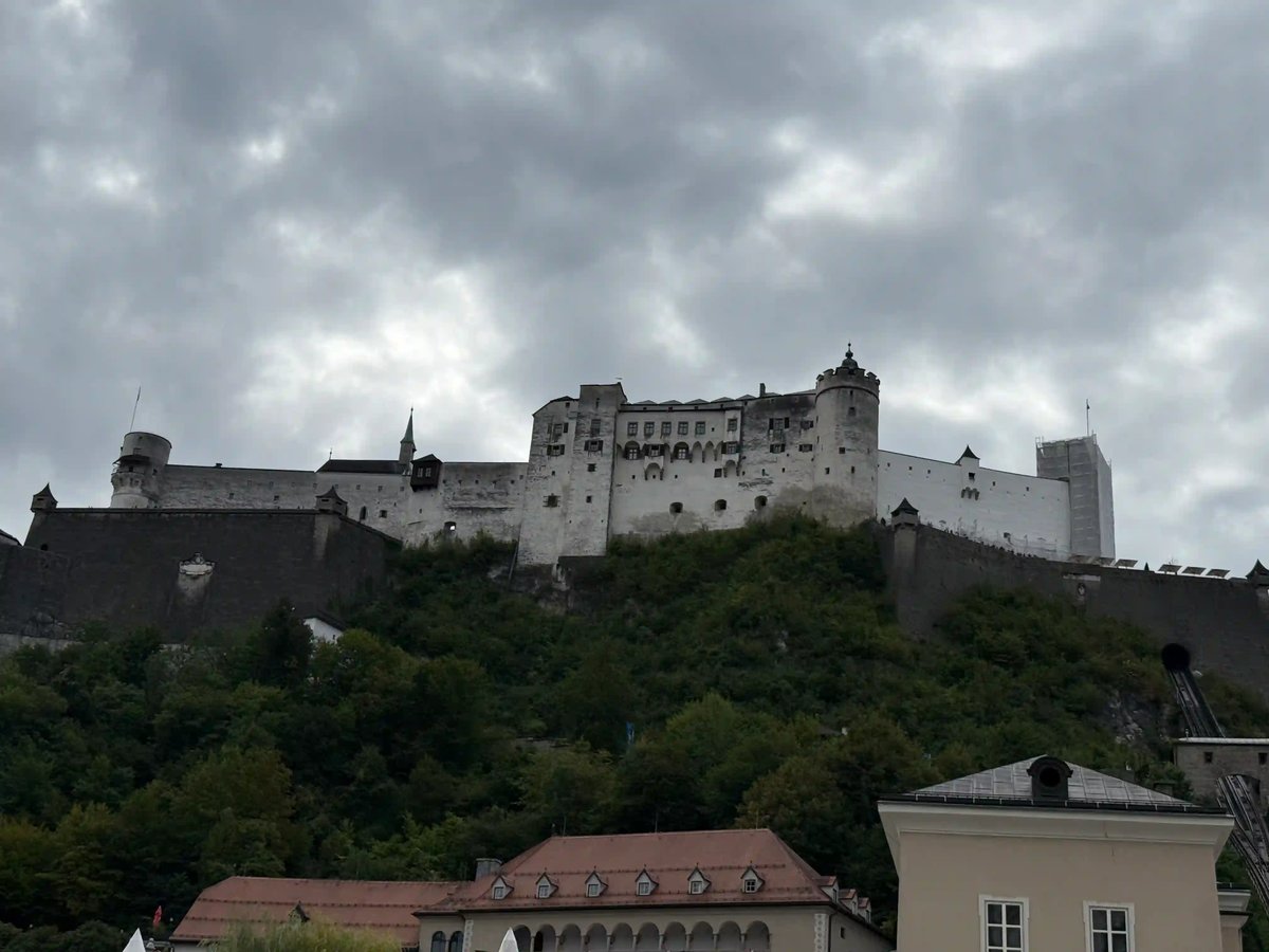 Forteresse de Hohensalzburg surplombant les toits de Salzbourg sous un ciel nuageux.