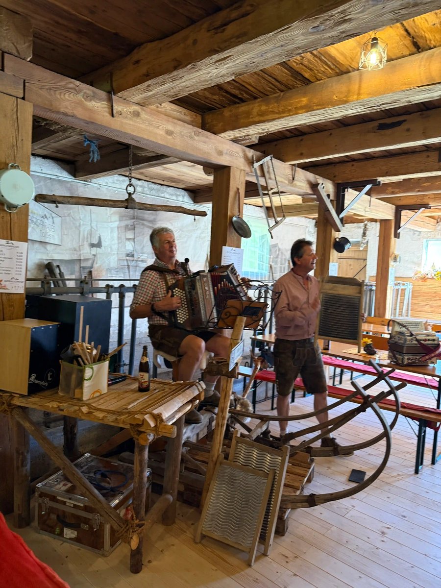 Deux musiciens jouent de l'accordéon et d'un instrument à cordes dans une ferme rustique