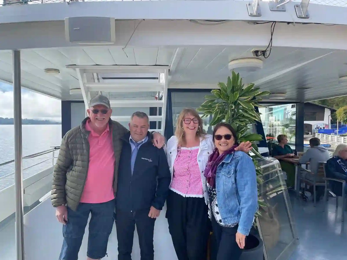 Quatre voyageurs souriants posent ensemble sur le pont d'un bateau