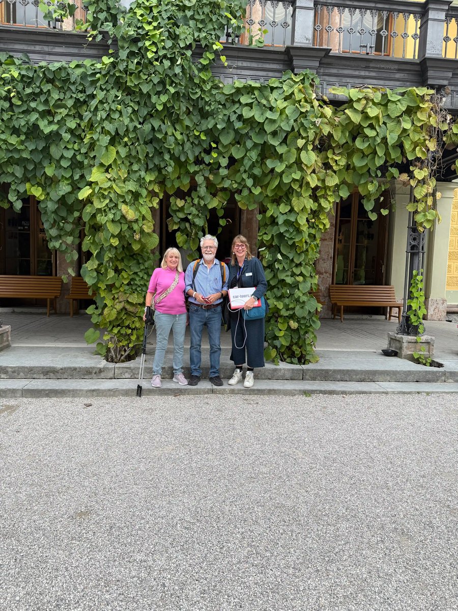 Trois voyageuses souriantes posent devant une façade recouverte de vigne