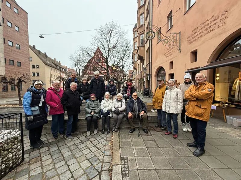 Reisegruppe in winterlicher Kleidung in historischer Altstadt mit Fachwerkhaus