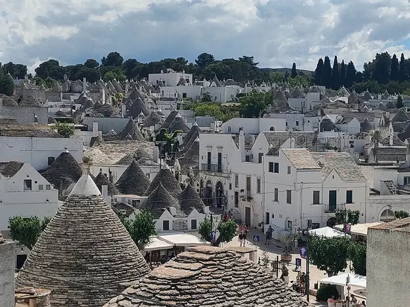 Stadt mit Trulli Häusern, weissen Gebäuden und kegelförmigen Dächern
