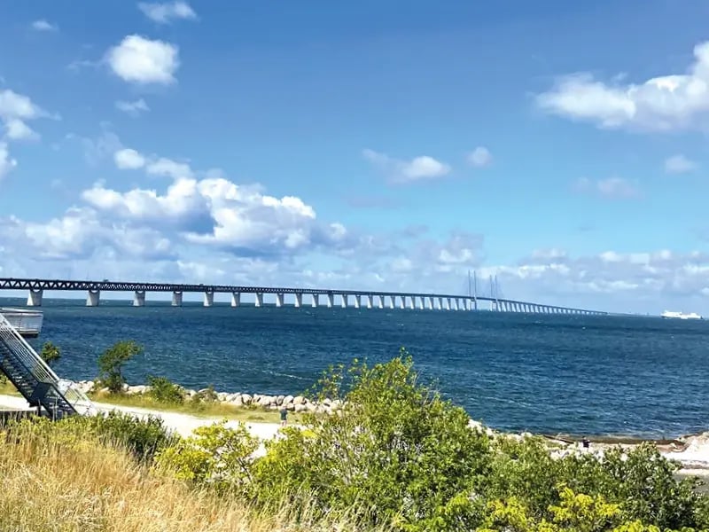 Lange Brücke über das Meer mit Küste, Vegetation und blauem Himmel