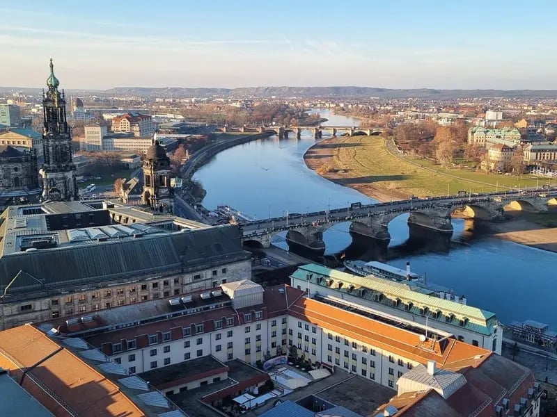 Stadtansicht mit Fluss, mehreren Brücken und historischen Gebäuden im warmen Abendlicht