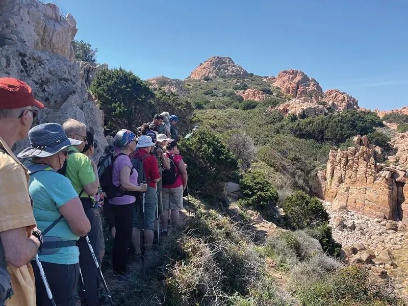 Groupe de randonneurs sur un sentier étroit en paysage rocheux