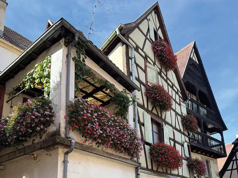 Fachwerkhaus mit Blumen geschmückt und Balkon unter blauem Himmel