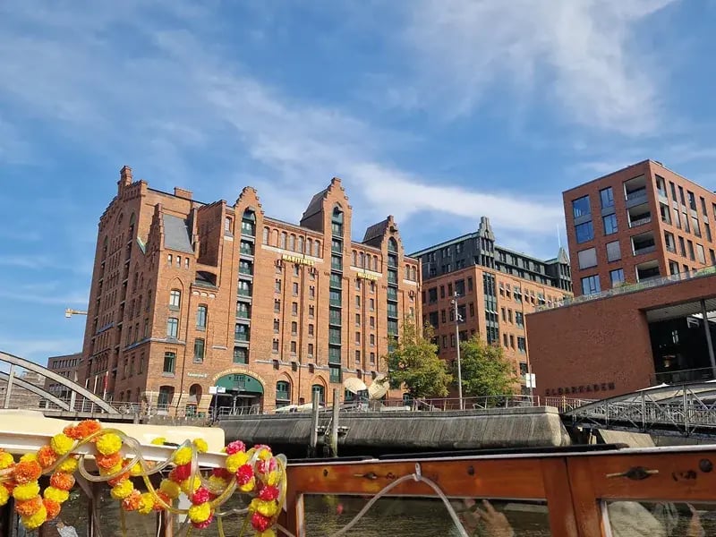 Backsteingebäude am Wasser in Hamburg mit moderner Architektur und Boot im Vordergrund