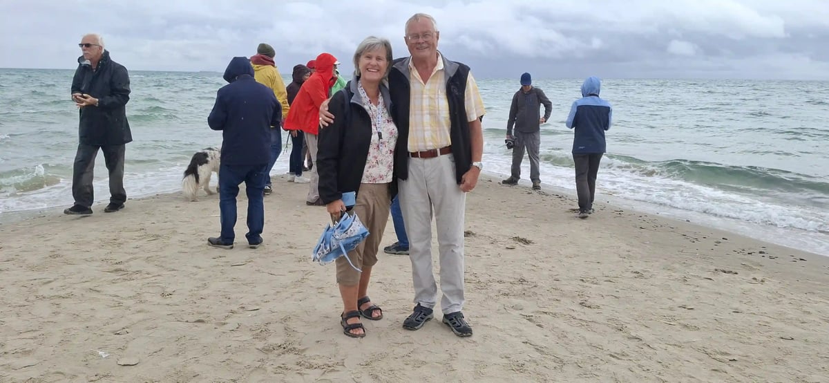 Lachendes Paar am Strand vor der rauen dänischen Nordsee
