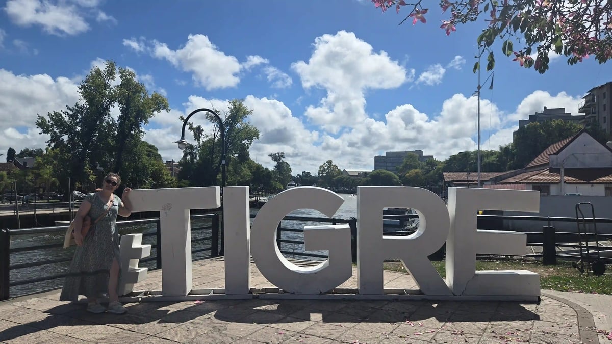 Frau neben grossen Tigre-Buchstaben an einer Uferpromenade