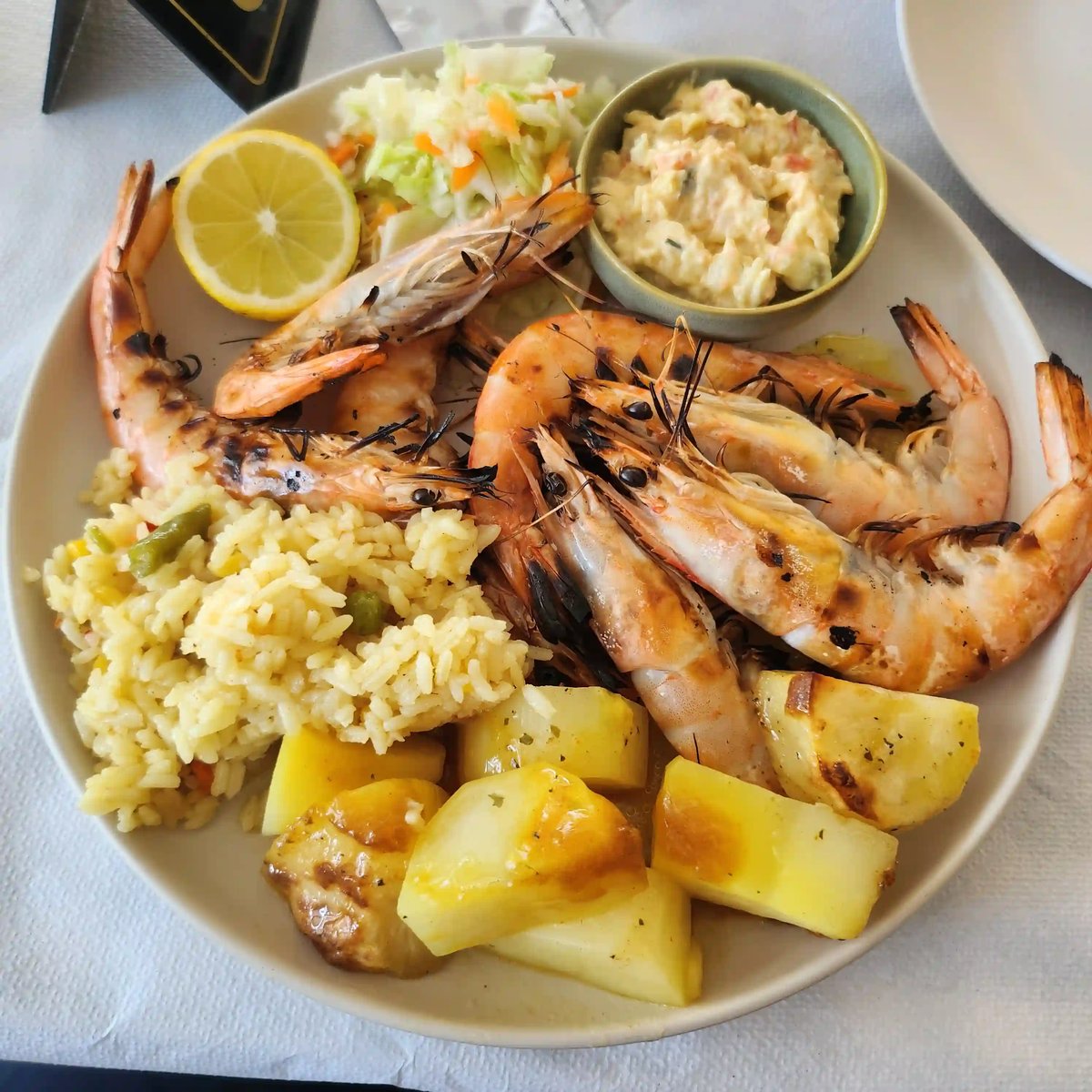 Gegrillte Garnelen mit Reis, Kartoffeln, Salat und Zitrone als typisch mediterranes Gericht
