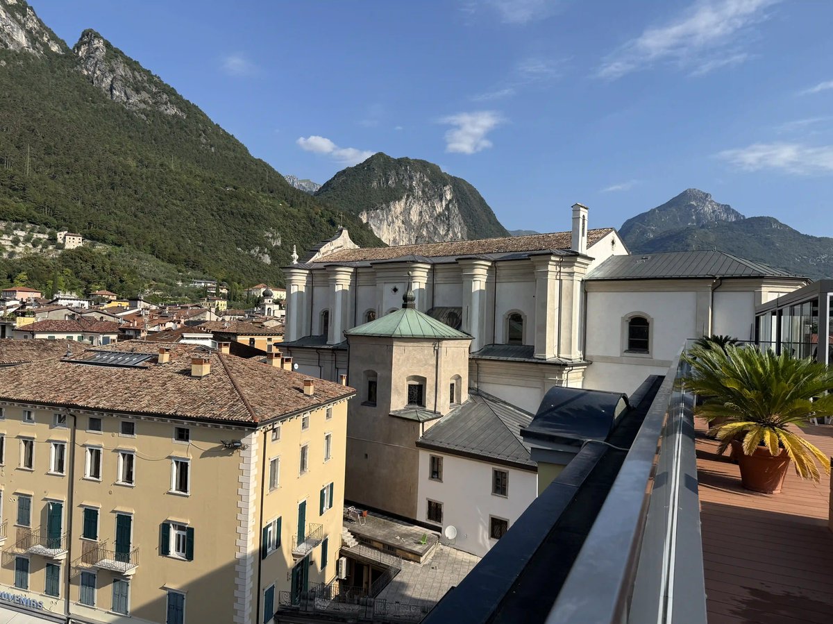 Dächer und historische Gebäude von Riva del Garda vor grünen Bergen