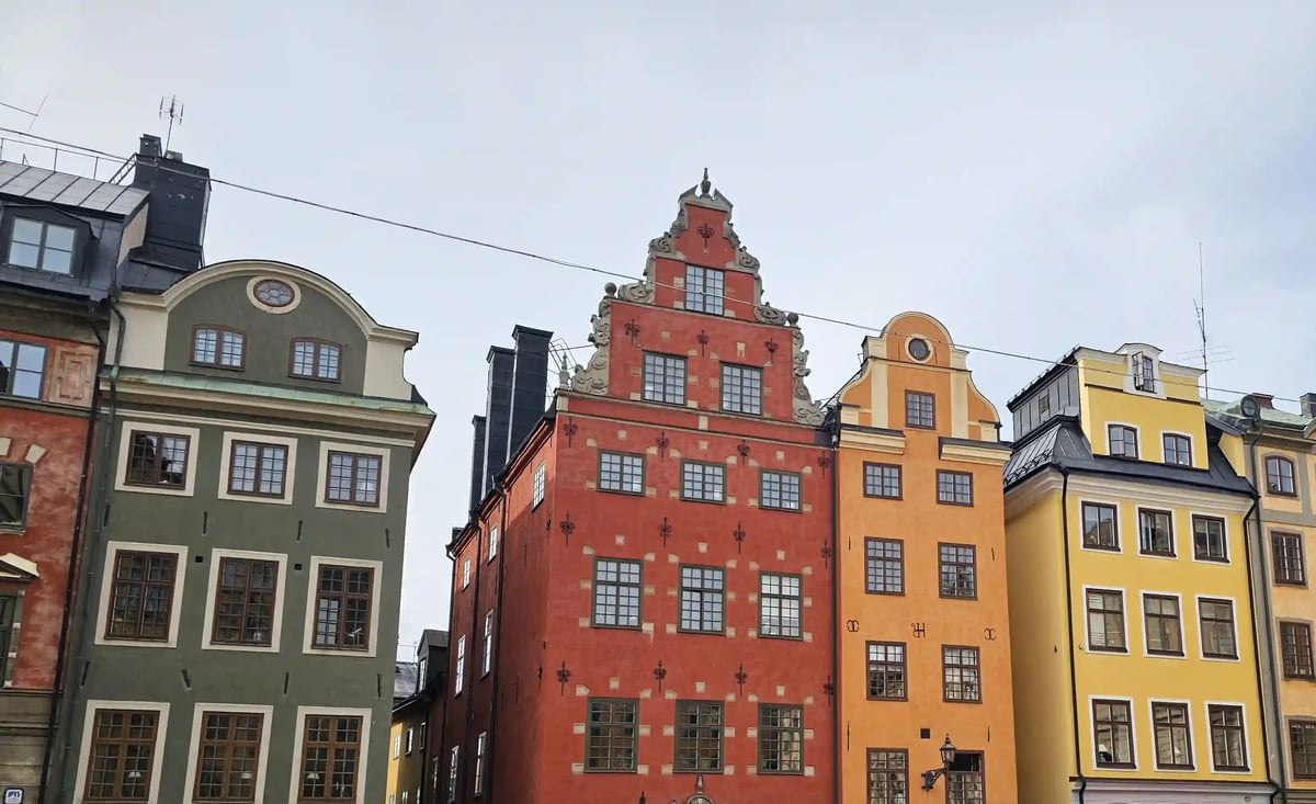 Historische Häuser mit grünen, roten, orangefarbenen und gelben Fassaden in Gamla Stan in Stockholm