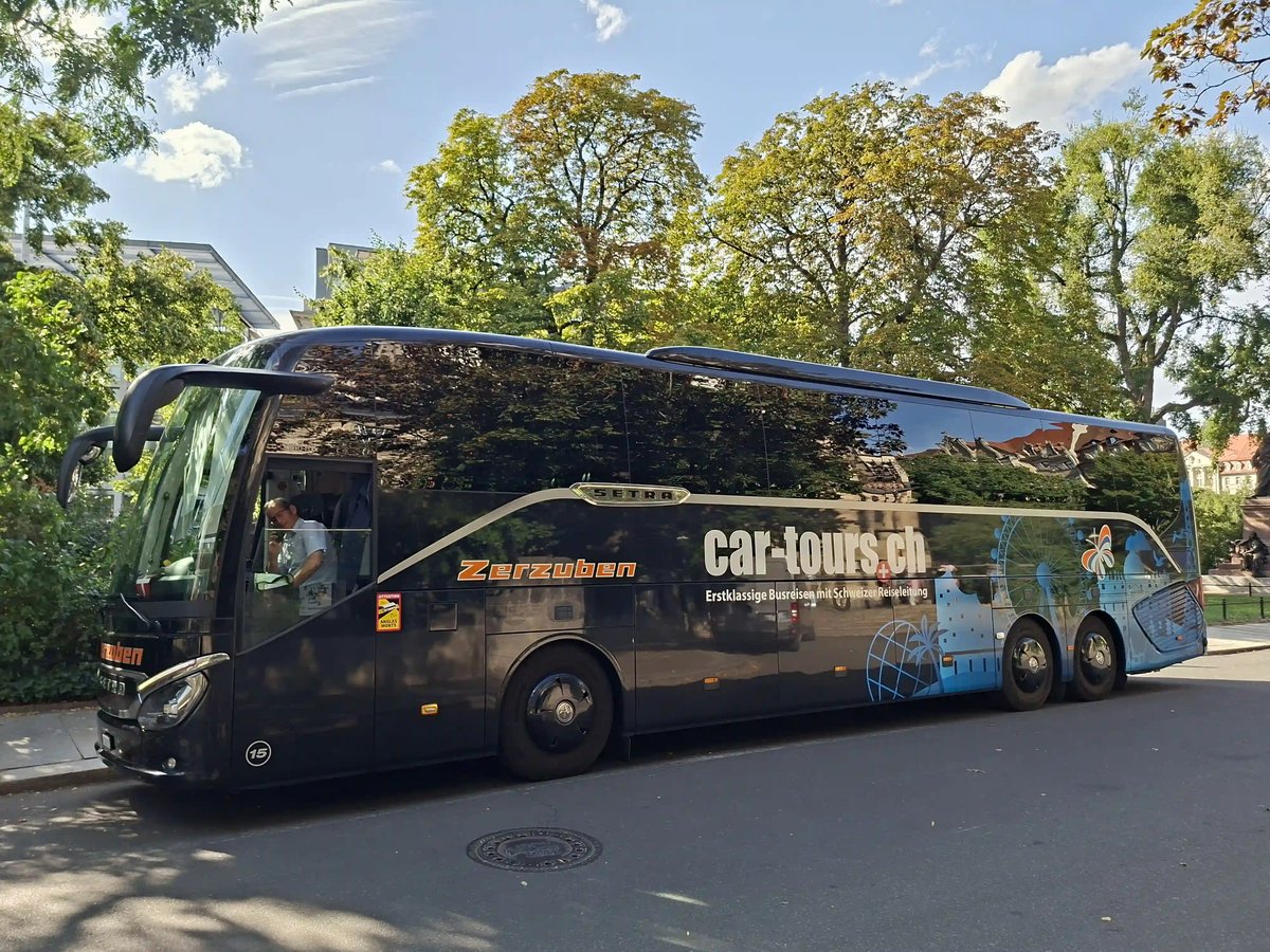 Schwarzer car-tours.ch Reisebus an einer von Bäumen gesäumten Strasse
