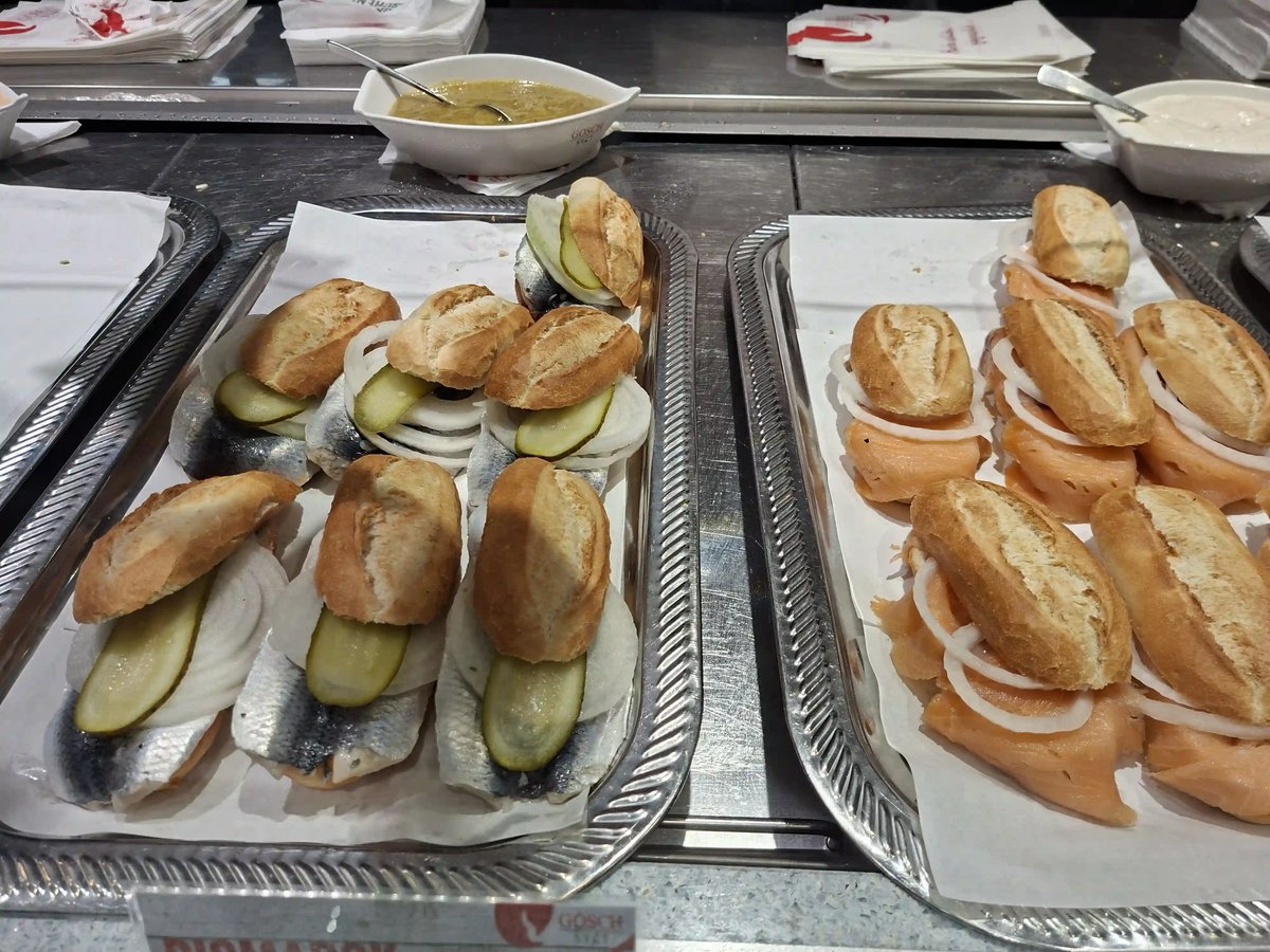 Fischbrötchen mit Hering, Lachs, Zwiebeln und Gurken auf zwei Servierplatten