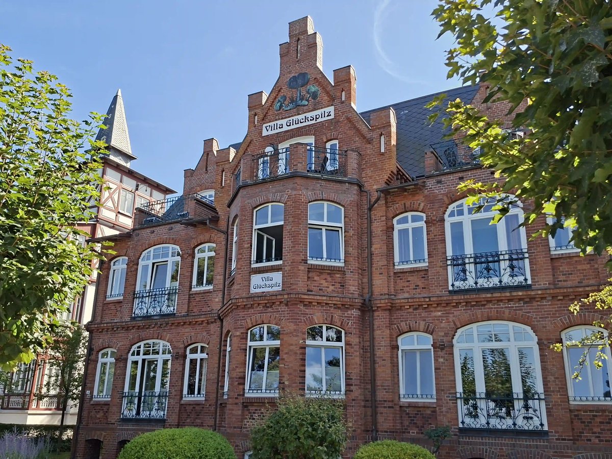 Historische Villa Glückspilz aus rotem Backstein mit weissen Fenstern und Balkonen