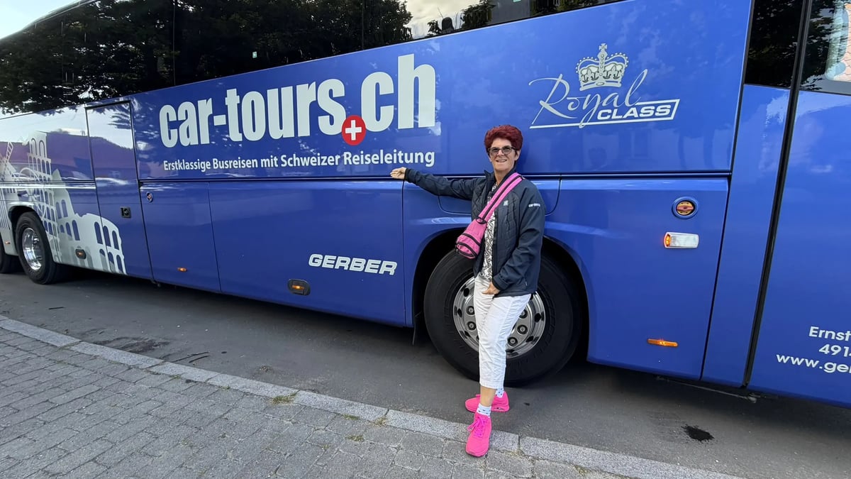 Reiseleiterin vor einem blauen Royal Class Reisebus von car-tours.ch