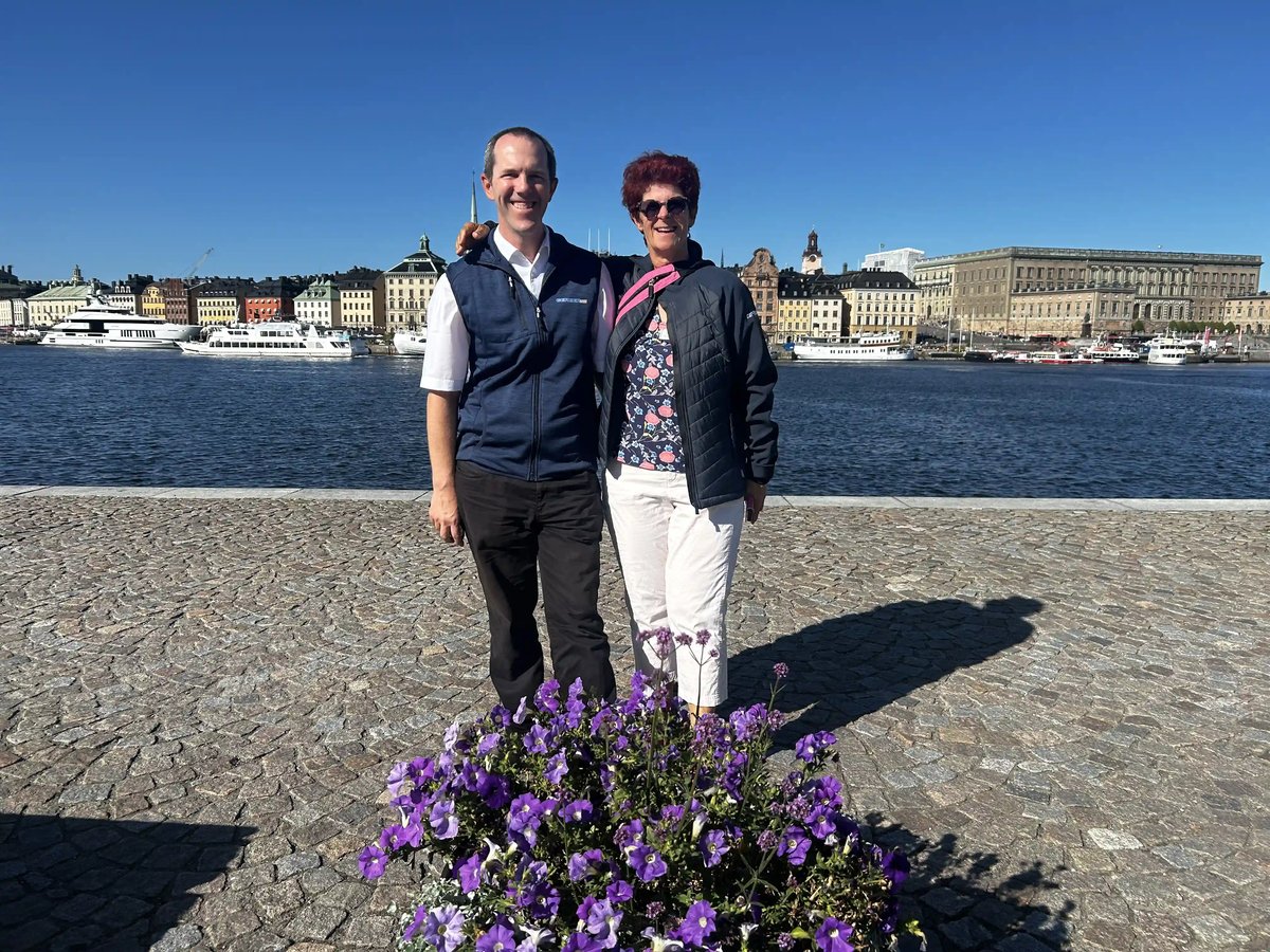 Reiseleiterin und Chauffeur am Wasser mit Blick auf die Altstadt von Stockholm