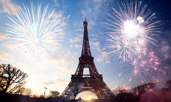 Eiffelturm in Paris bei Sonnenuntergang mit buntem Feuerwerk am Himmel