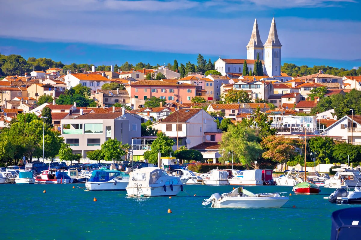 Hafen von Medulin mit Booten, Altstadt und Kirche mit zwei Türmen an der Adriaküste