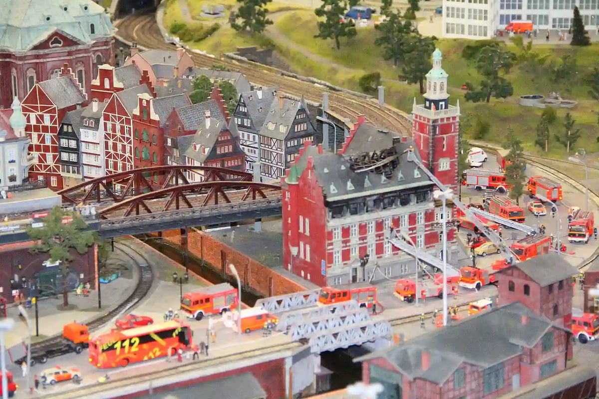 Detailreiche Miniaturstadt mit Bahnhof, Feuerwehrfahrzeugen und historischen Gebäuden im Miniatur Wunderland.