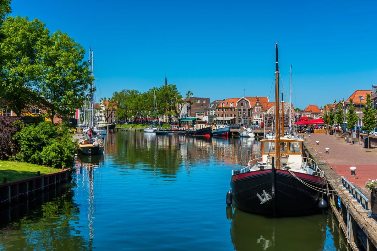 Historischer Hafen mit Segelschiffen, Kirche und alten Gebäuden bei klarem Himmel