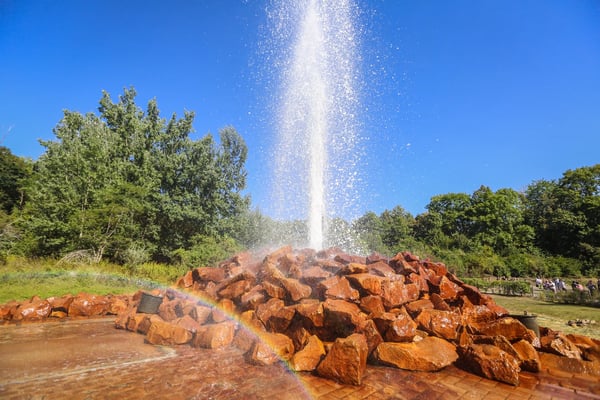 Welthöchster Kaltwassergeysir in Andernach schiesst Wasser in die Höhe vor blauem Himmel