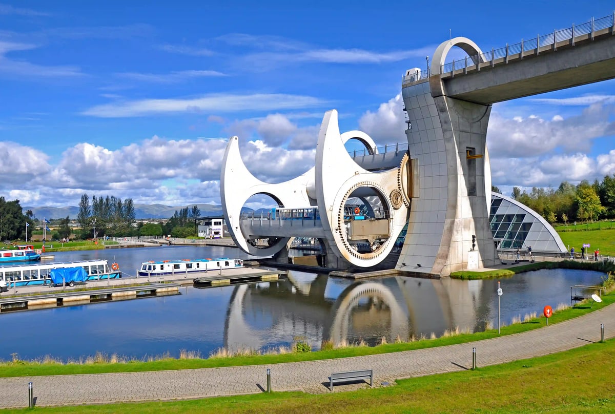 Modernes Schiffshebewerk Falkirk Wheel über einem Kanal mit spiegelndem Wasser und blauem Himmel