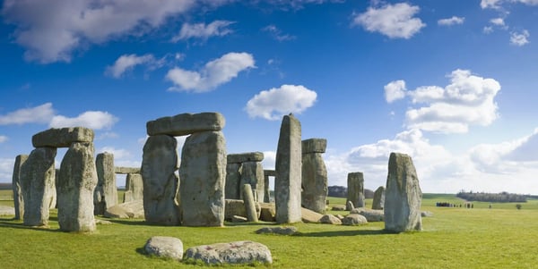 Steinkreis von Stonehenge auf einer grünen Ebene unter blauem Himmel mit vereinzelten Wolken