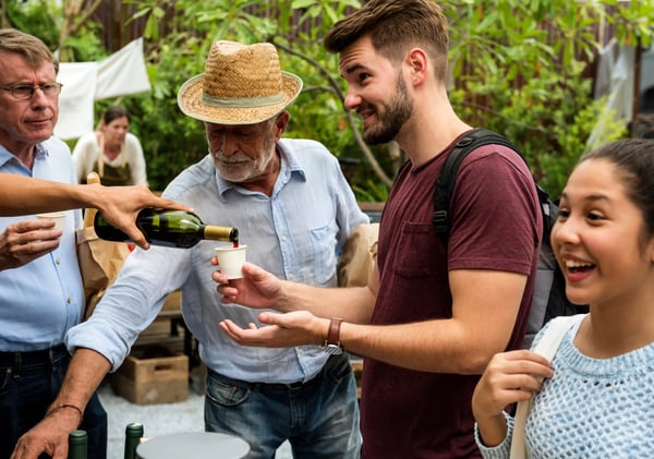 Gruppe von Menschen verkostet Wein bei einer genussvollen Weinprobe im Freien